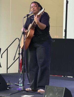 Jodie Coste artiste en train de chanter à la guitare