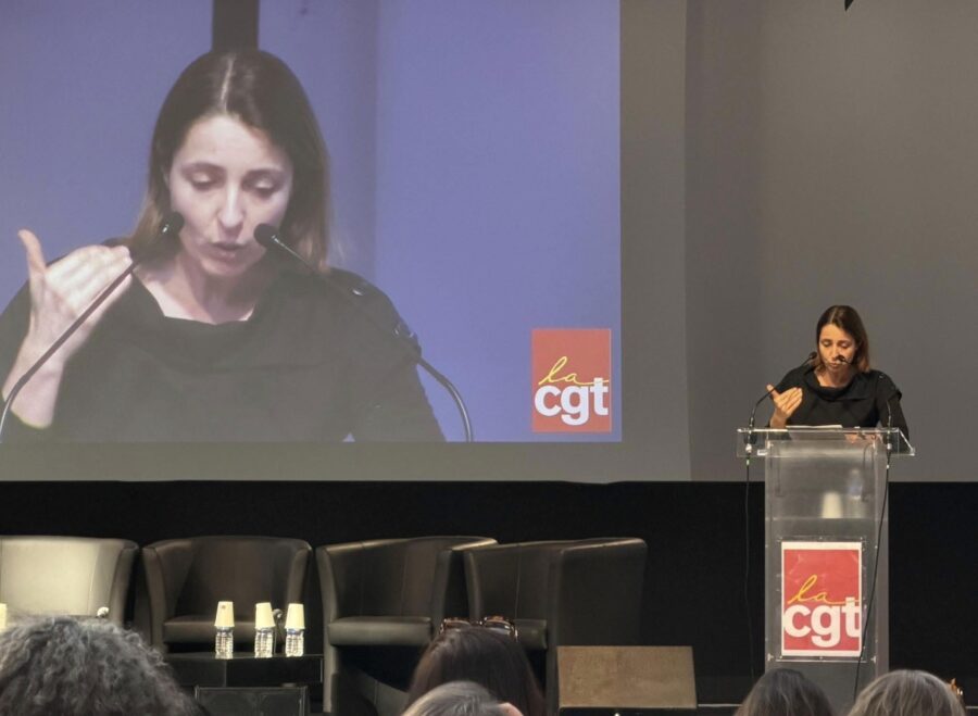 Photo de Sophie Binet en plein discours en tribune devant l'assemblée réunie devant elle.